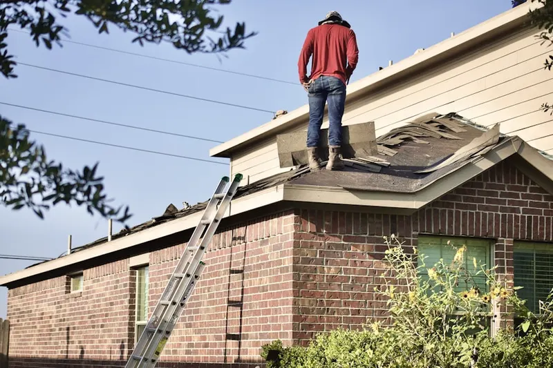 Professional roofer working on a residential roof in Warren